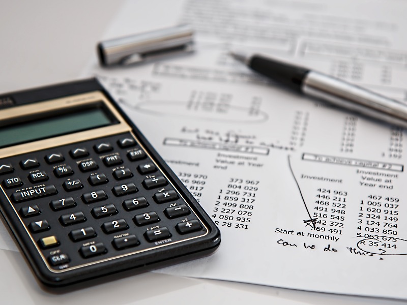 Calculator and report with pen on table