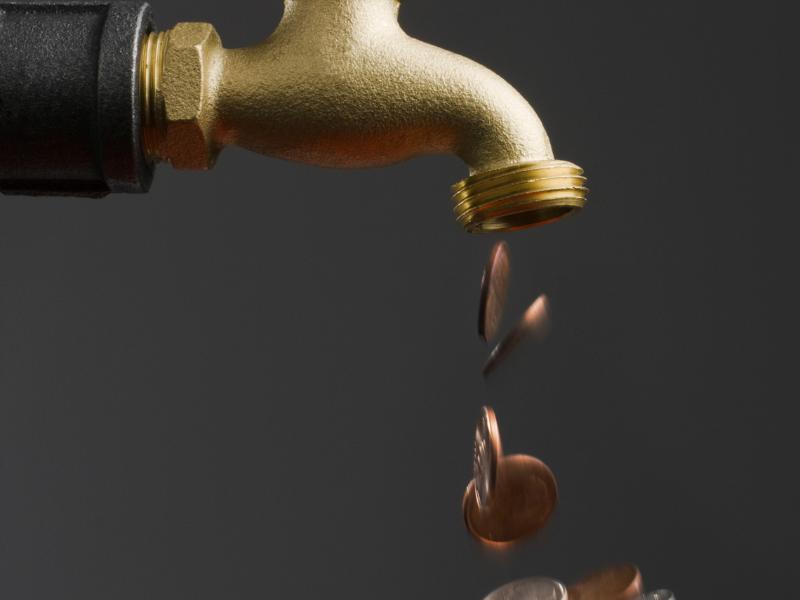 a water faucet with coins falling out of it