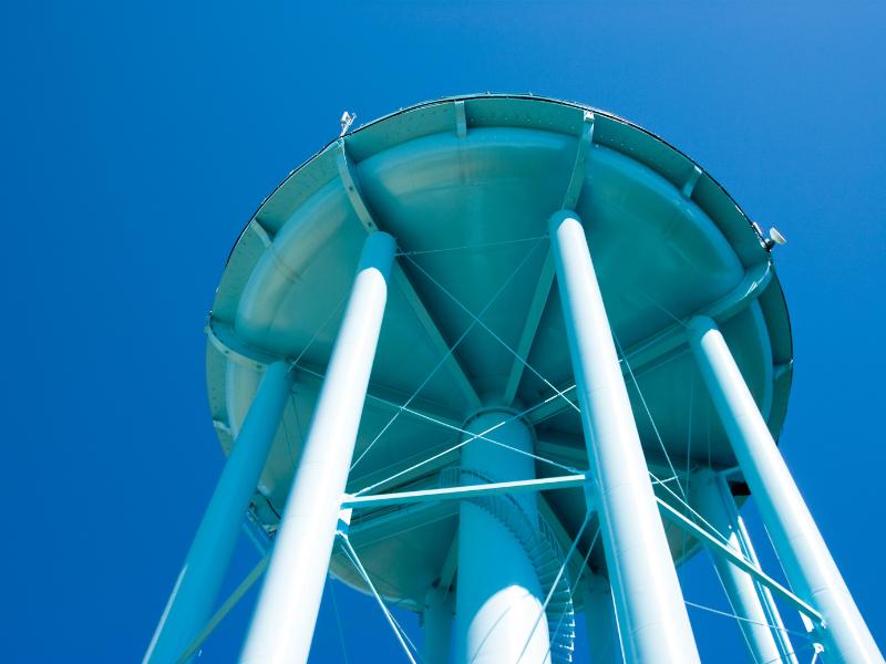 upward photo of light blue water tower against blue sky