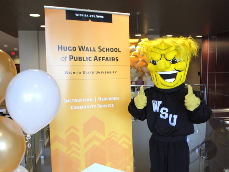 Wu gives a thumbs up at a Hugo Wall sign