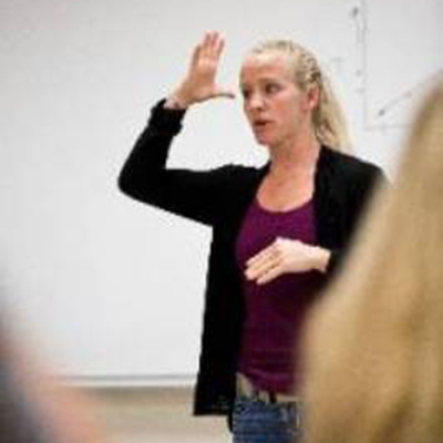 Woman signing in front of class