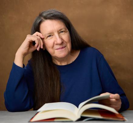 Photo of Dr. Sterrett smiling with an open book in front of her