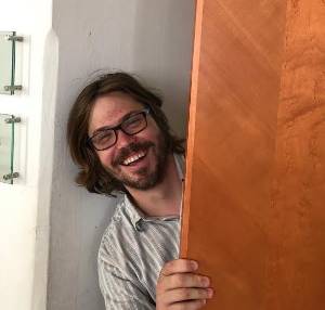 Photo of Dr. Hill laughing, from behind a door