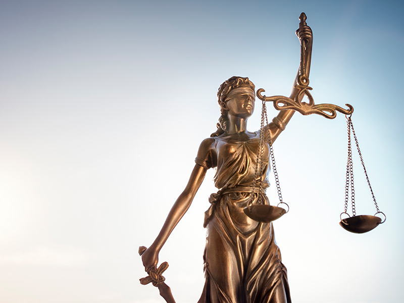 Image of justice sculpture depicted with a blindfold and holding a balancing scale