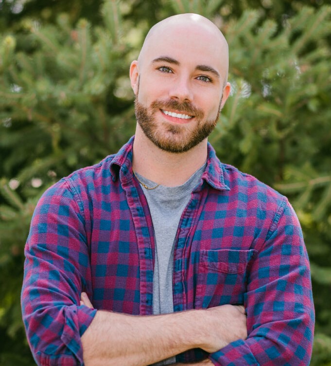 bald young man with arms crossed