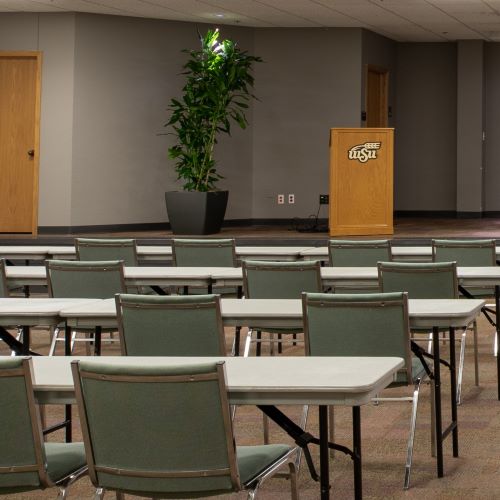 Seats and tables facing a podium at the WSU Metroplex Center