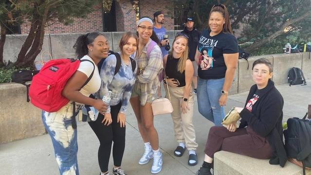 students standing and smiling in front of the Lindquist Building