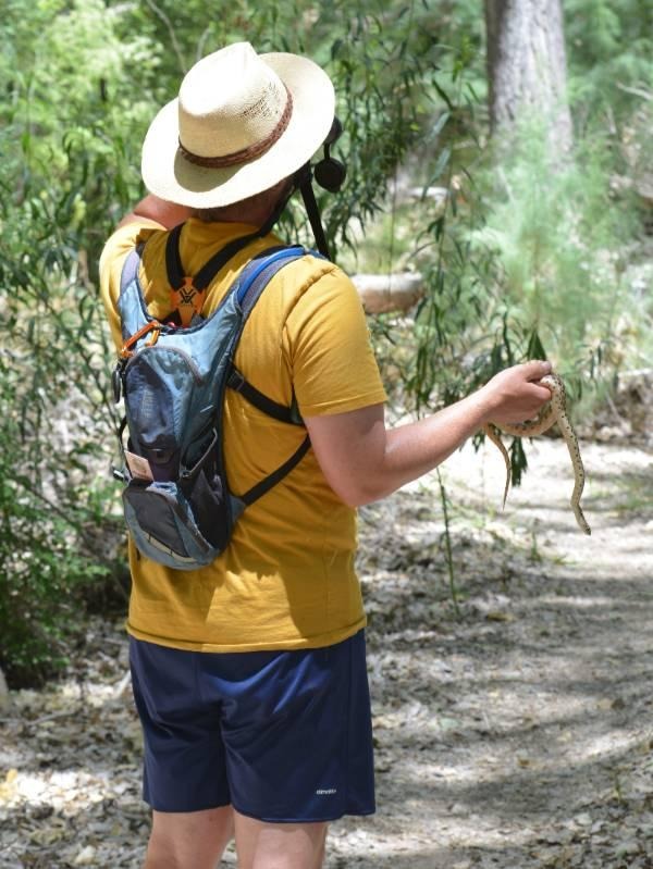 Luhring holds a gopher snake while birding and teaching his desert ecology class in Arizona. Photo by Emily Morton. 
