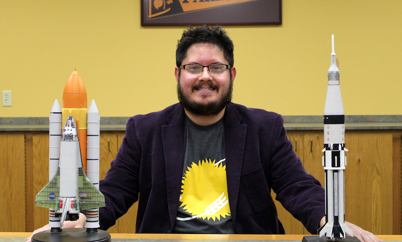 Photo: Jim Schwartz, assistant teaching professor of philosophy, shows two smaller scale models of a space shuttle and a rocket.