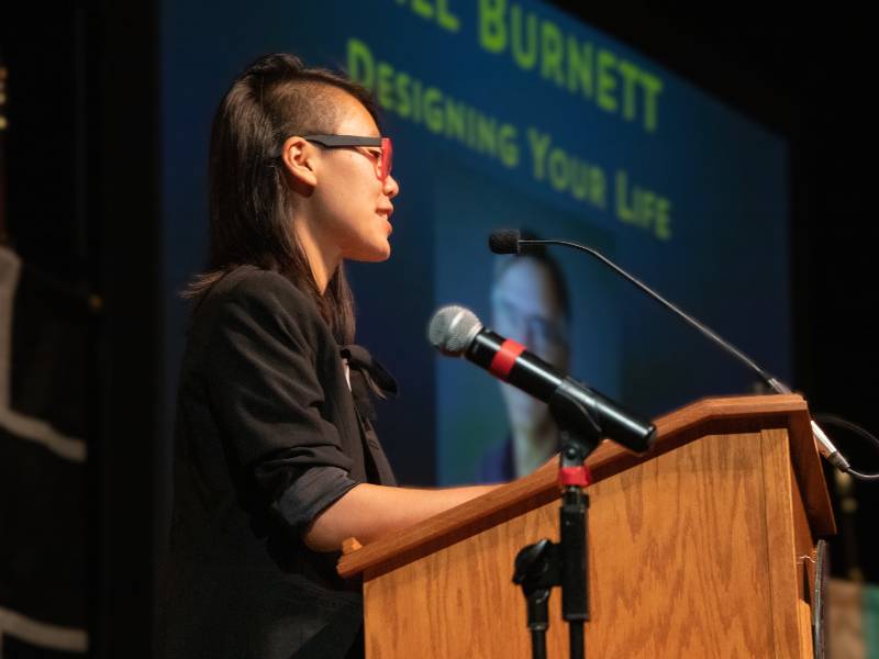 Student speaks at a podium during a book discussion.