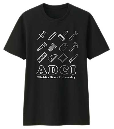 A black ADCI T-shirt depicting a white design of 12 icons representing different artist tools. The T-shirt says ADCI/Wichita State University