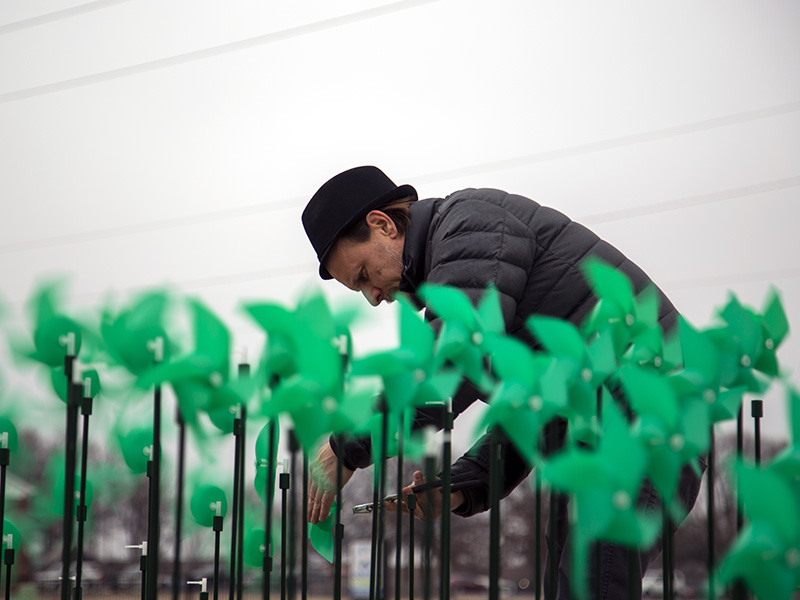 Levente Sulyok works to repair his installation on Wichita State's innovation campus.