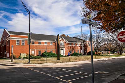 An exterior image of Henrion Hall with a crosswalk in the foreground.