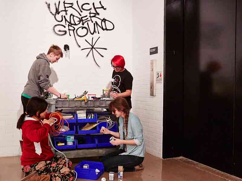Students work on installing an exhibition they co-curated at the Ulrich Museum of Art.