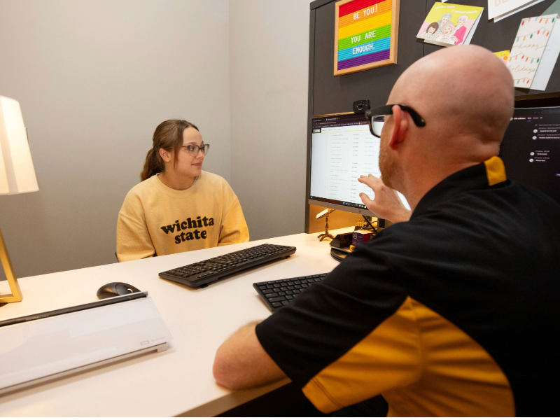 student meeting with an advisor who is pointing at a computer screen