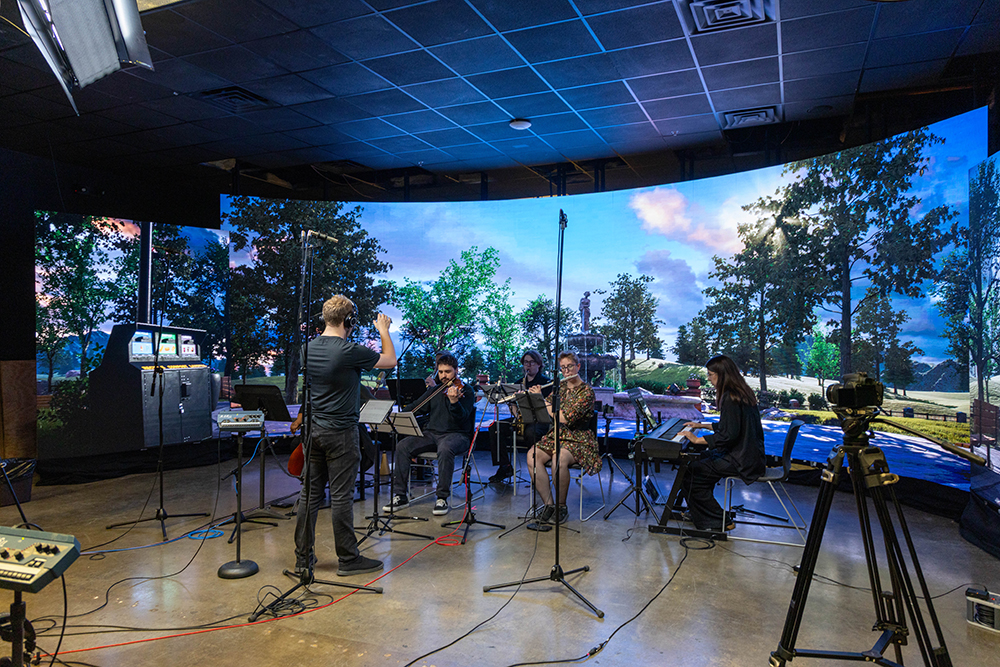 An orchestra in front of an LED screen.