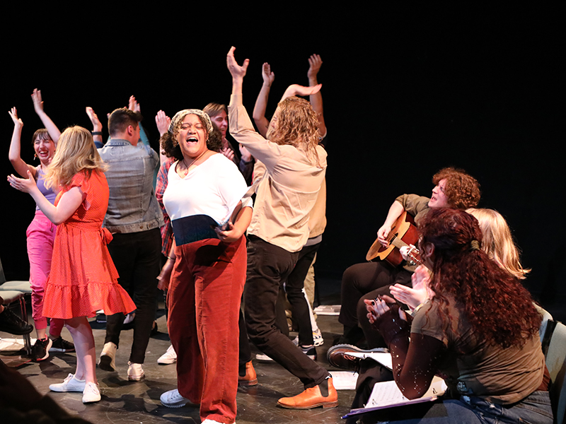 Students perform on a black box stage.
