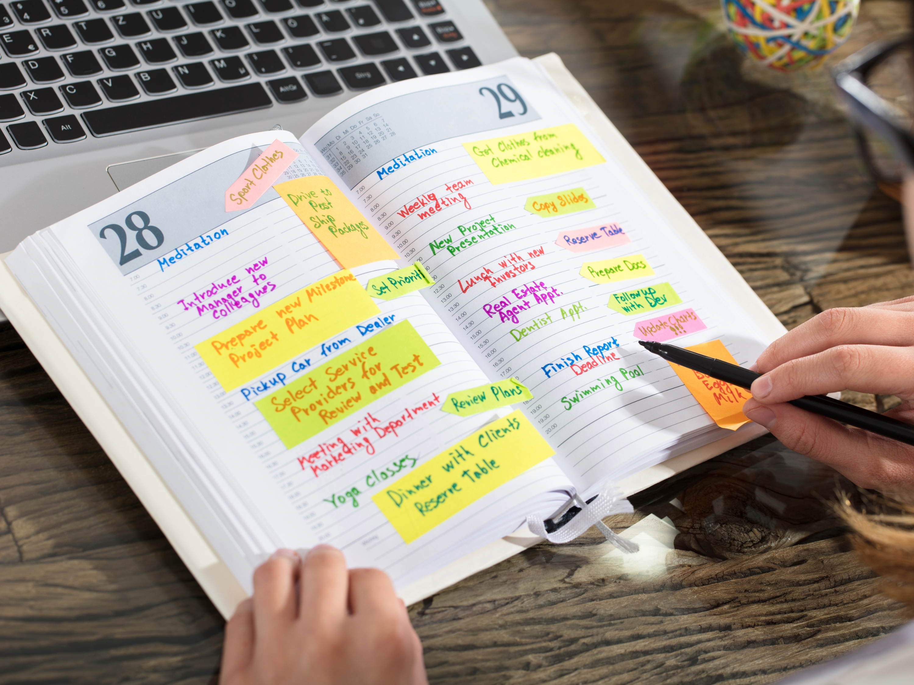 A schedule book with various post-it notes and highlights