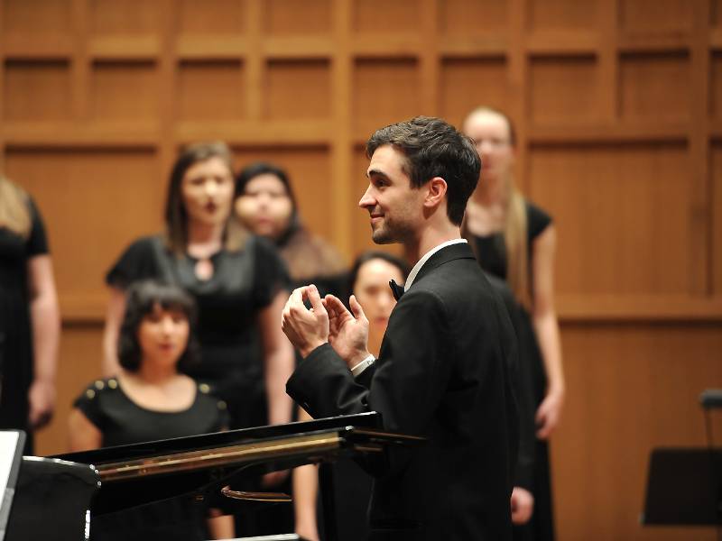 a graduate conductor in front of the women's glee club