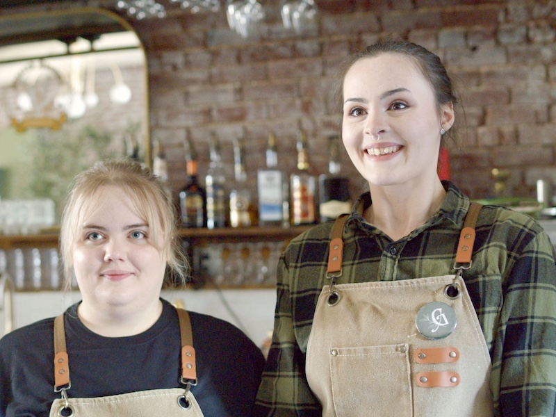 2 women in a coffee shop smiling