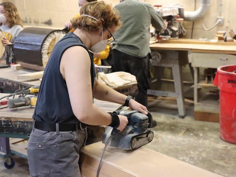 student in scene shop working on a set
