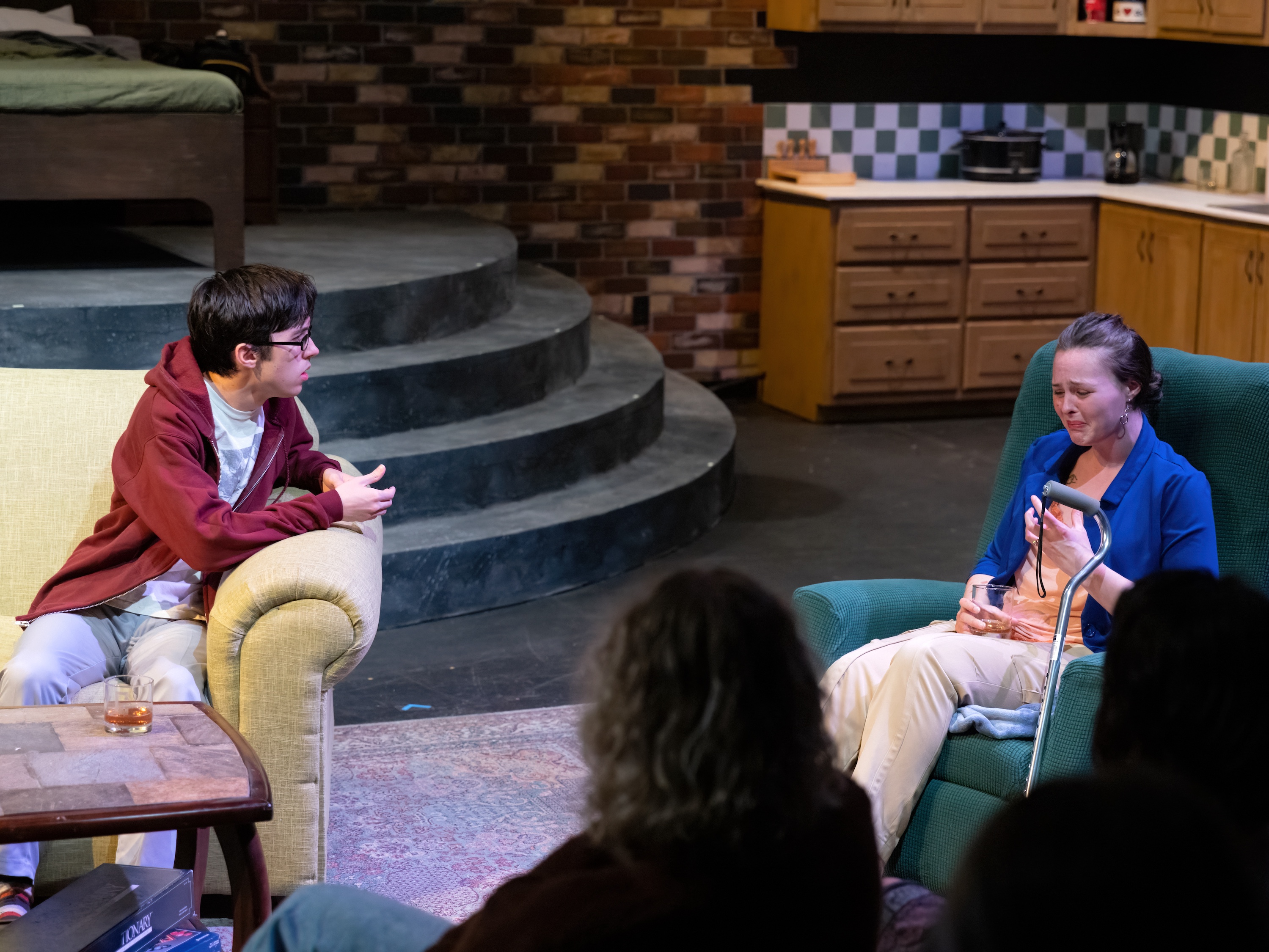 man on a couch talking with a woman crying from the 2026 production of Time Stands Still