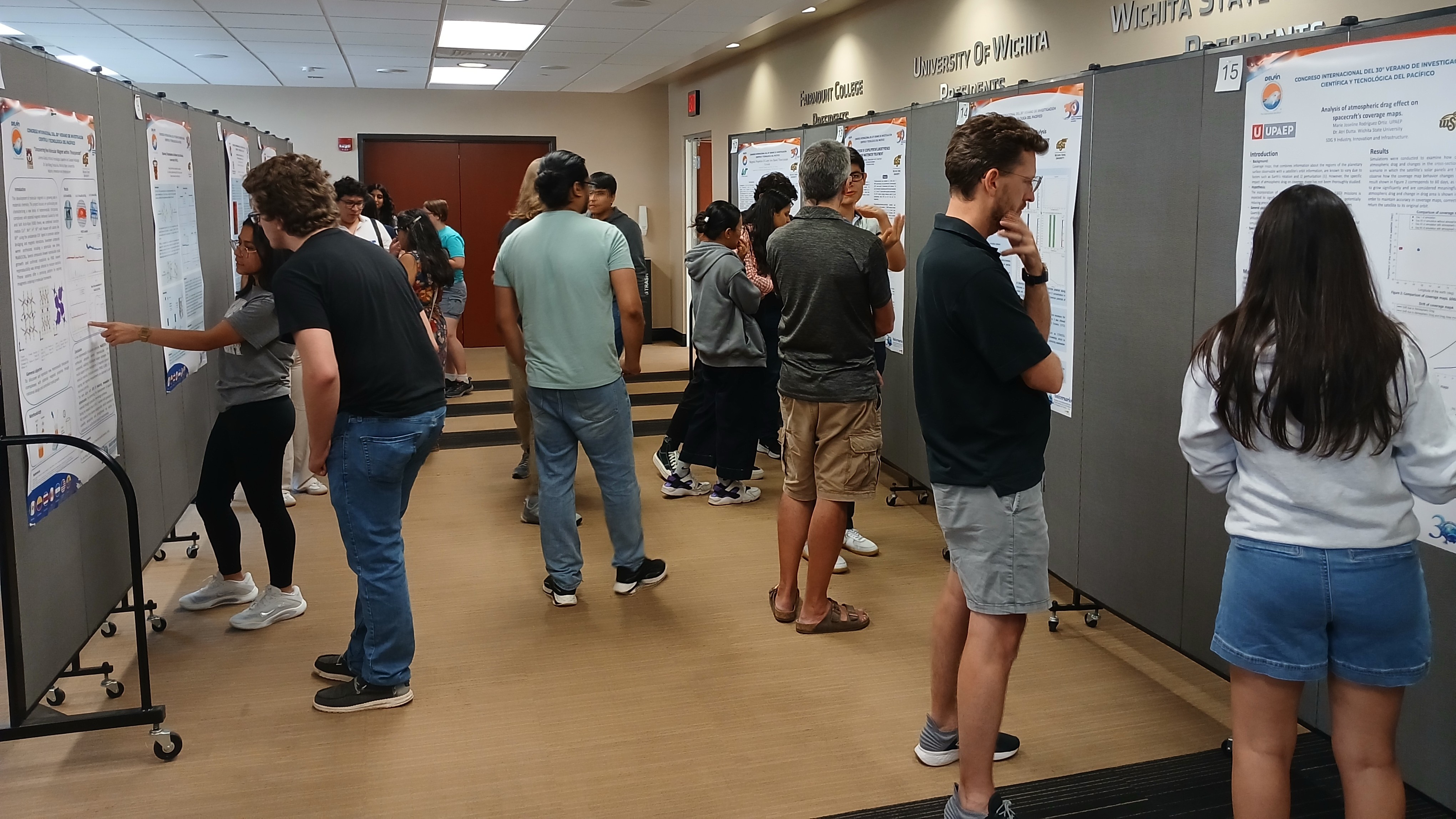 Delfin students presenting their research on campus. Students present their posters and some faculty and students are asking questions or listening to them.