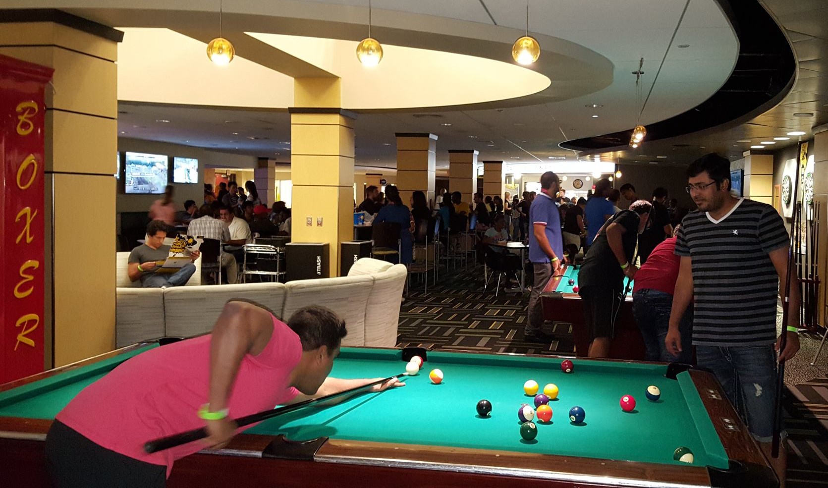 Students around a pool table playing pool 
