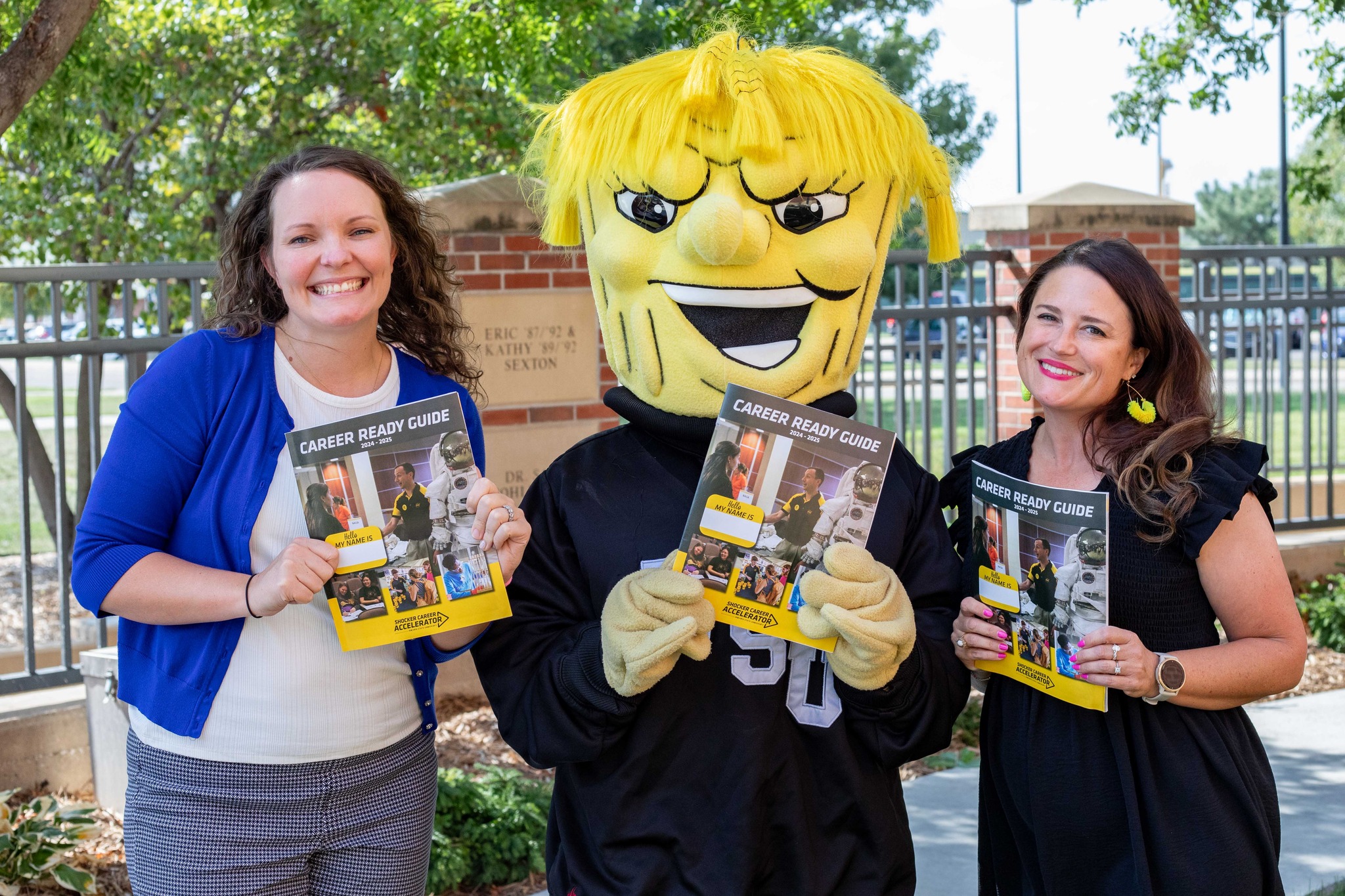 Wu and two female staff members of the Shocker Career Accelerator pose with a copy of the Career Guide.