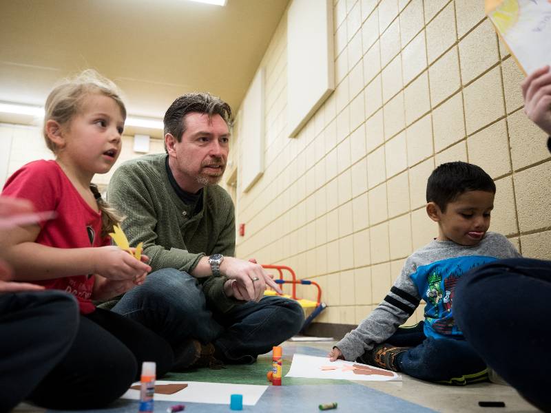 A counseling graduate student leads children in an activity