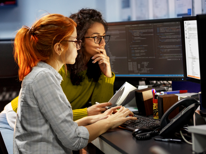 Female students working at computer terminal