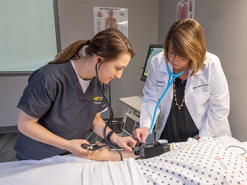 Students and faculty work on a simulation manikin