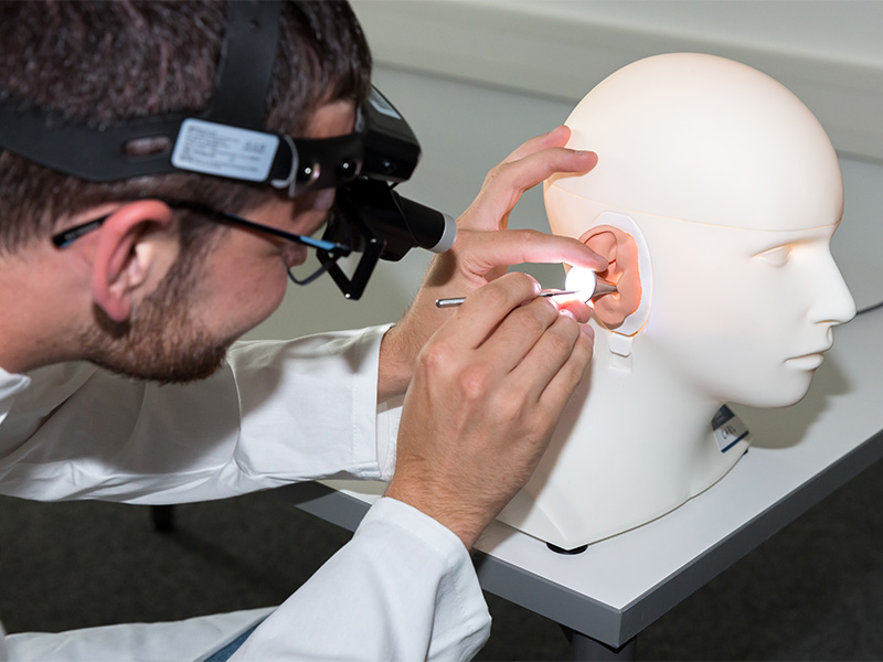 audiology student works on simulation manikin