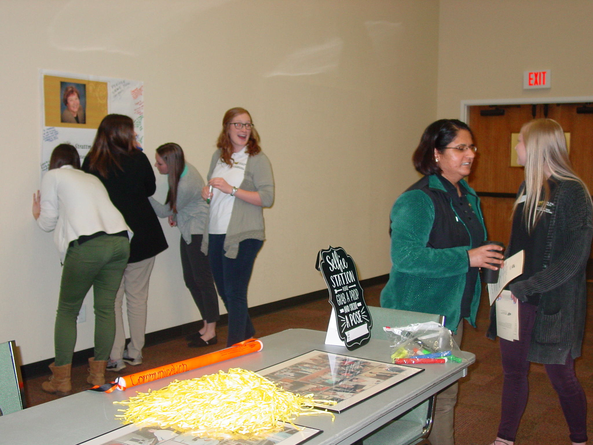 Guests signing poster at retirement reception. 