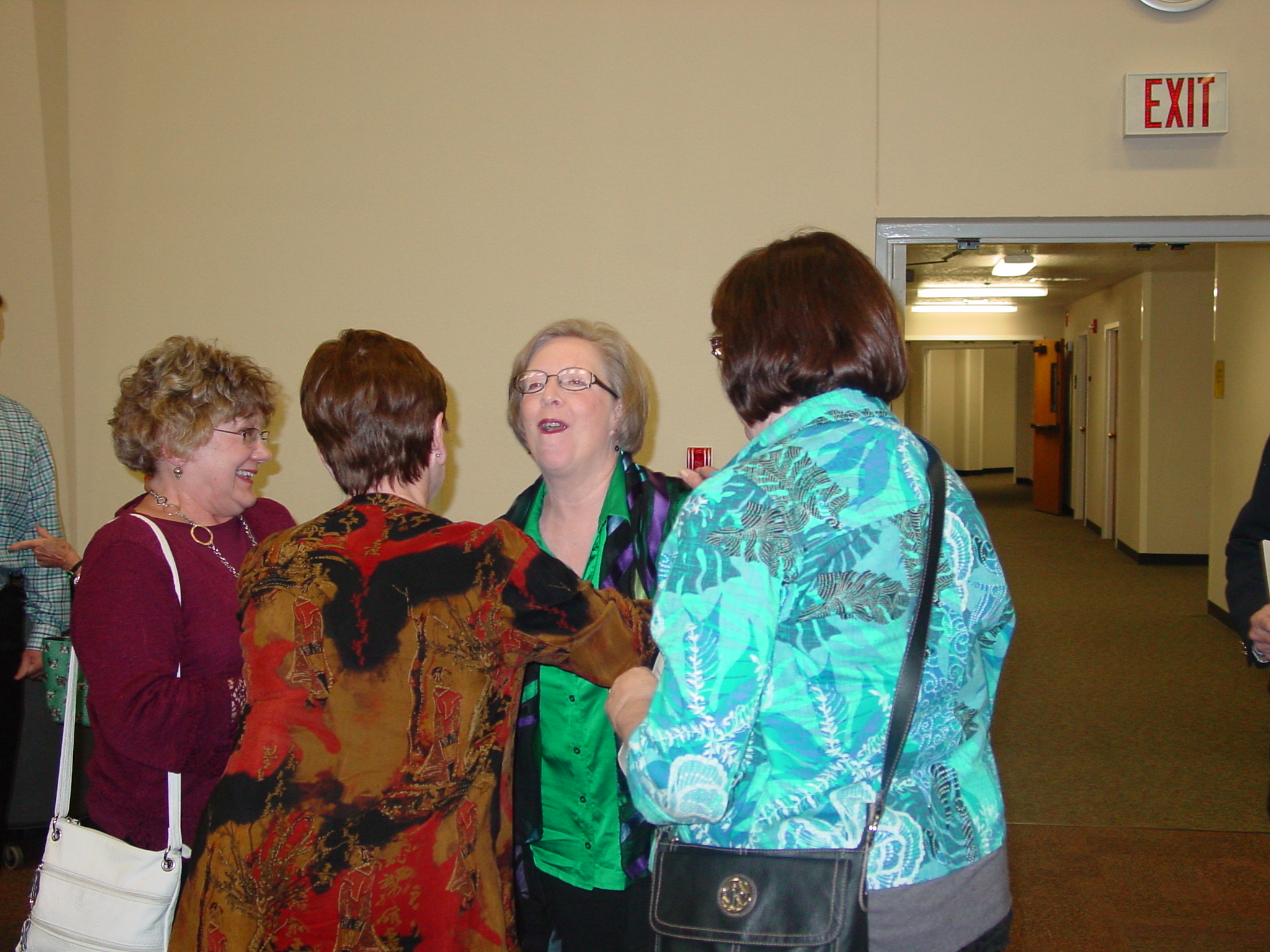 Guest laugh together in group at retirement reception. 