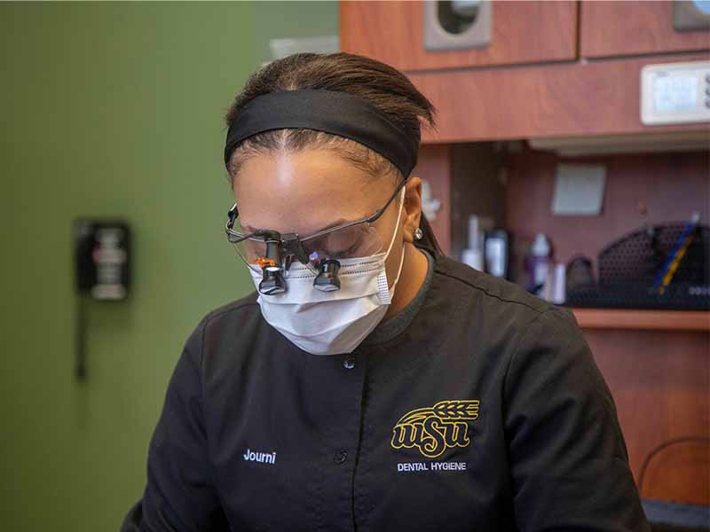 Dental Hygiene student working on patient