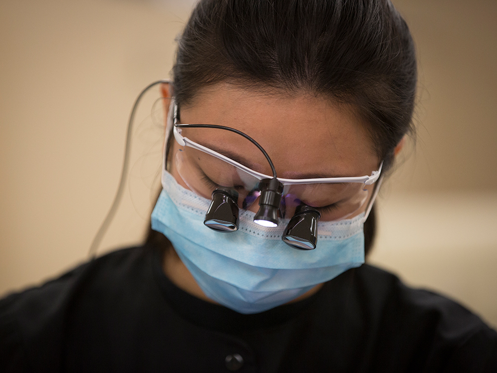 Dental hygiene student wearing dental eye loupes