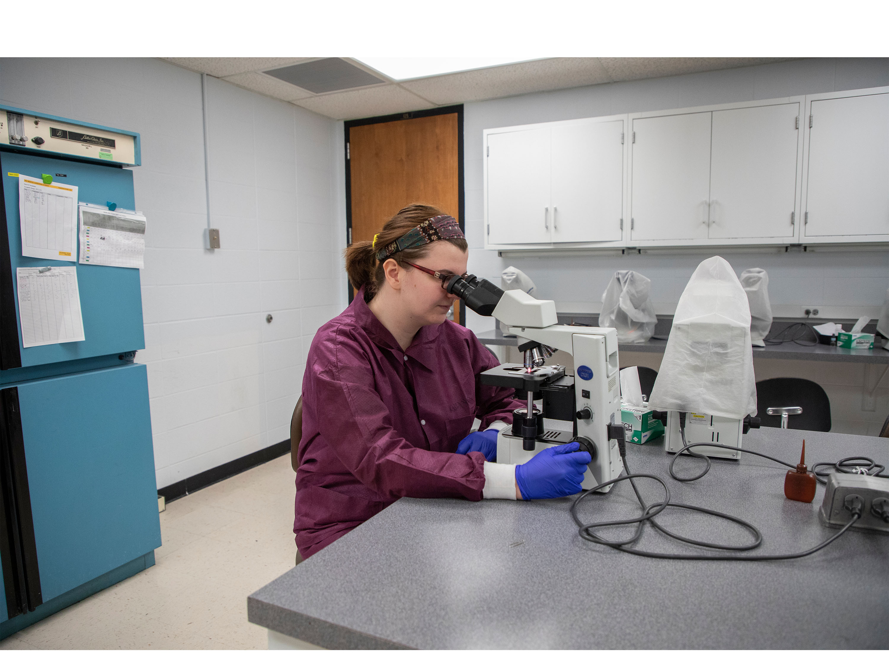 MLS student looking through microscope