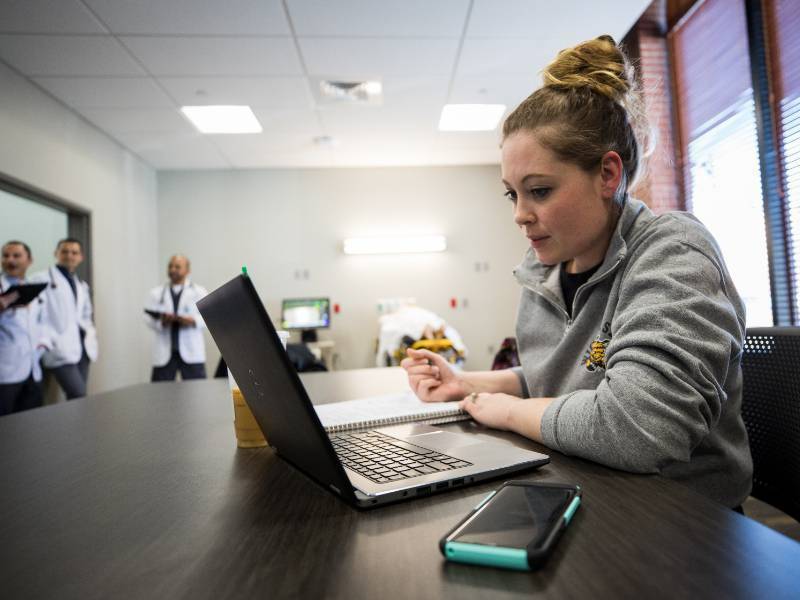 Student learning on computers with doctors in background