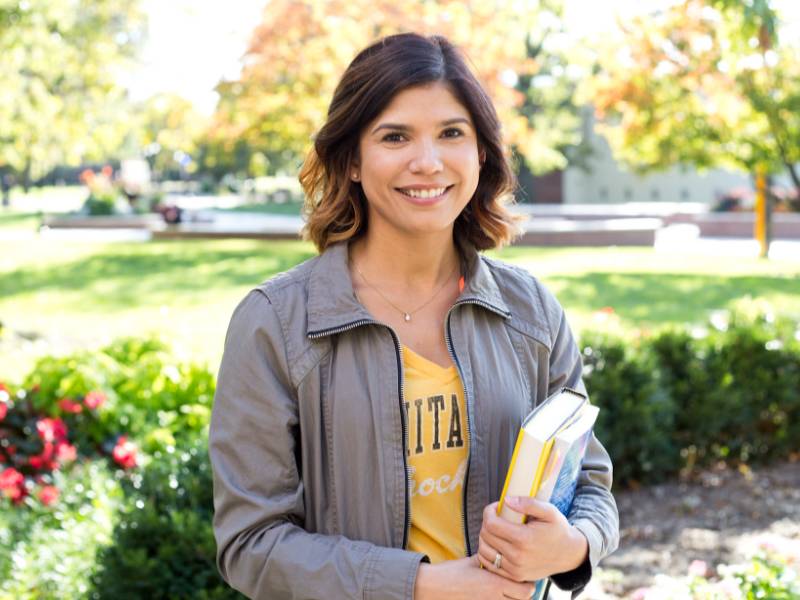 WSU Student carrying book outside