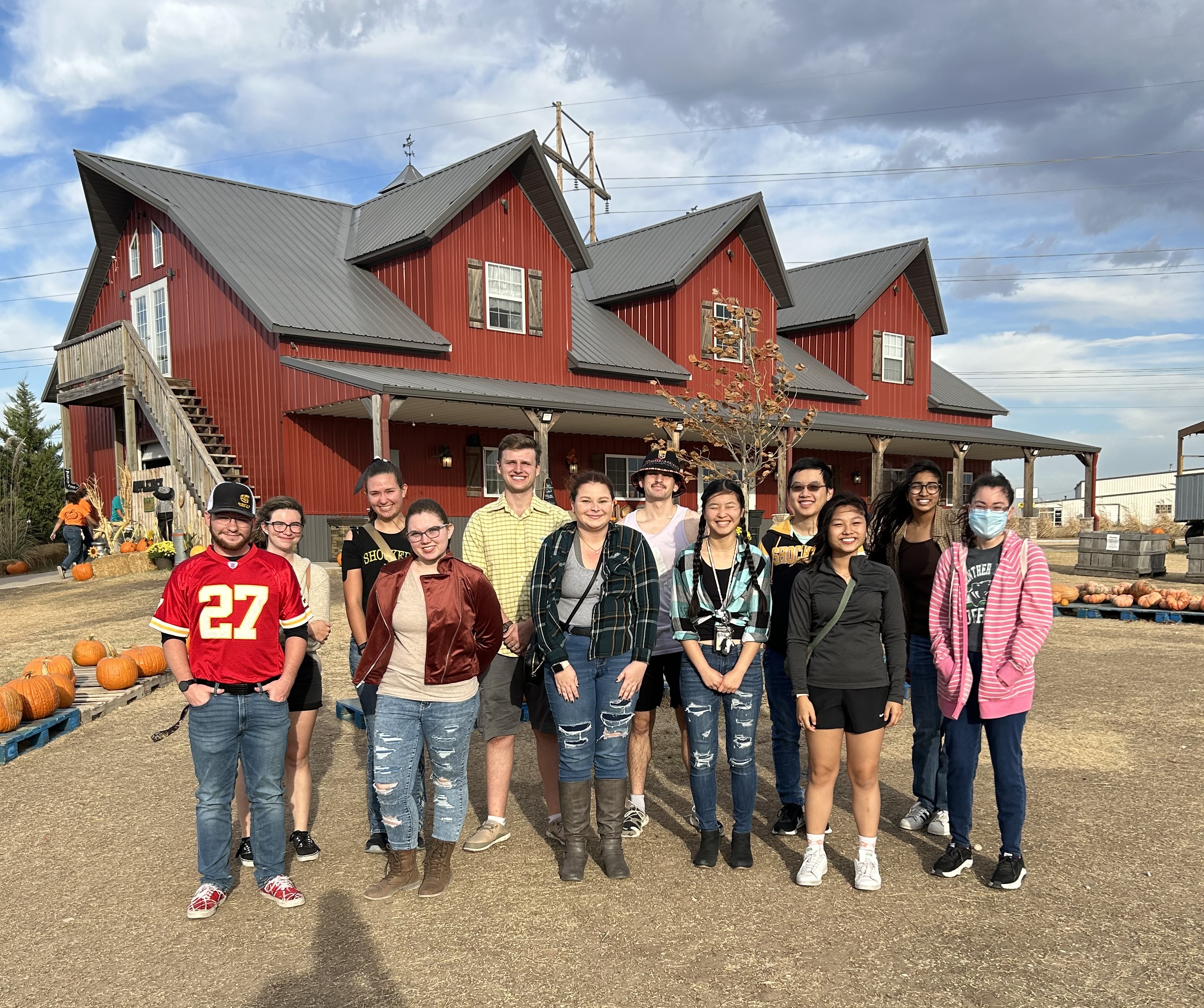 Students standing in a group with a barn in the background