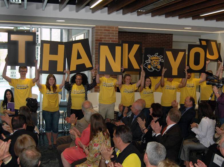 Honors students holding thank you signs.