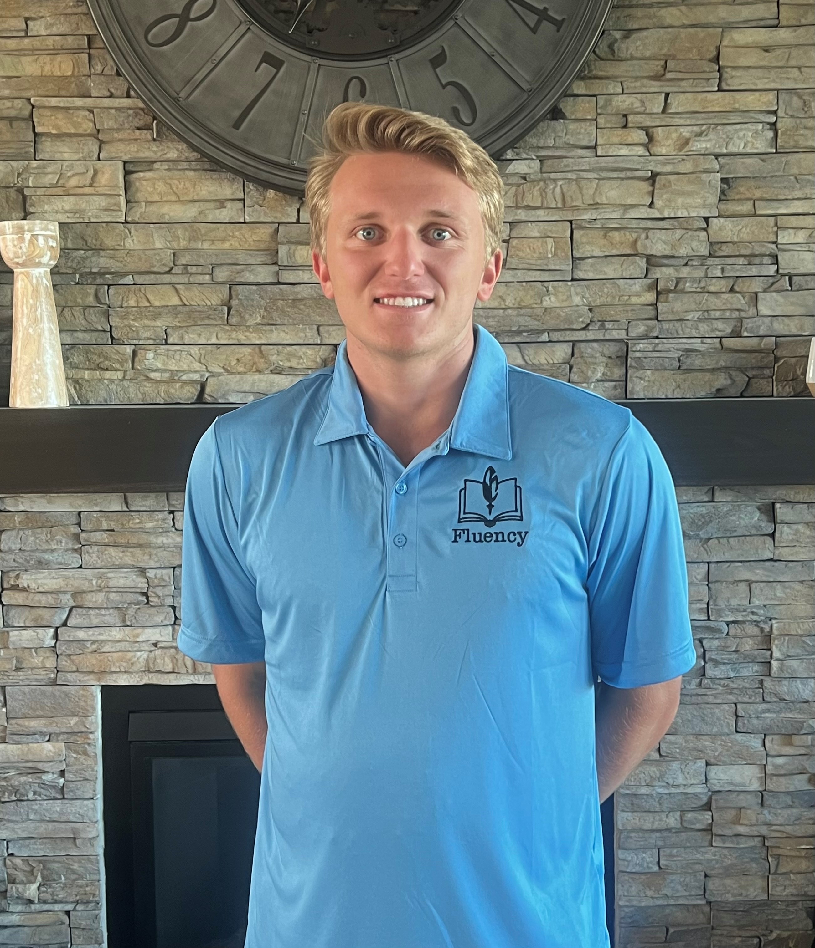 Grant Johnson wearing a Fluency polo in front of an ornate clock.