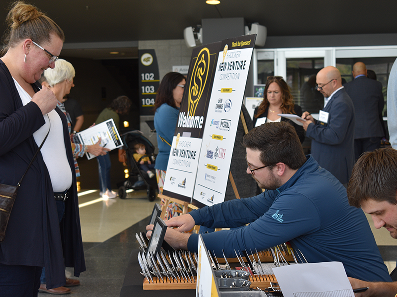 Volunteers hand judges their name tags and packets as they enter the competition.