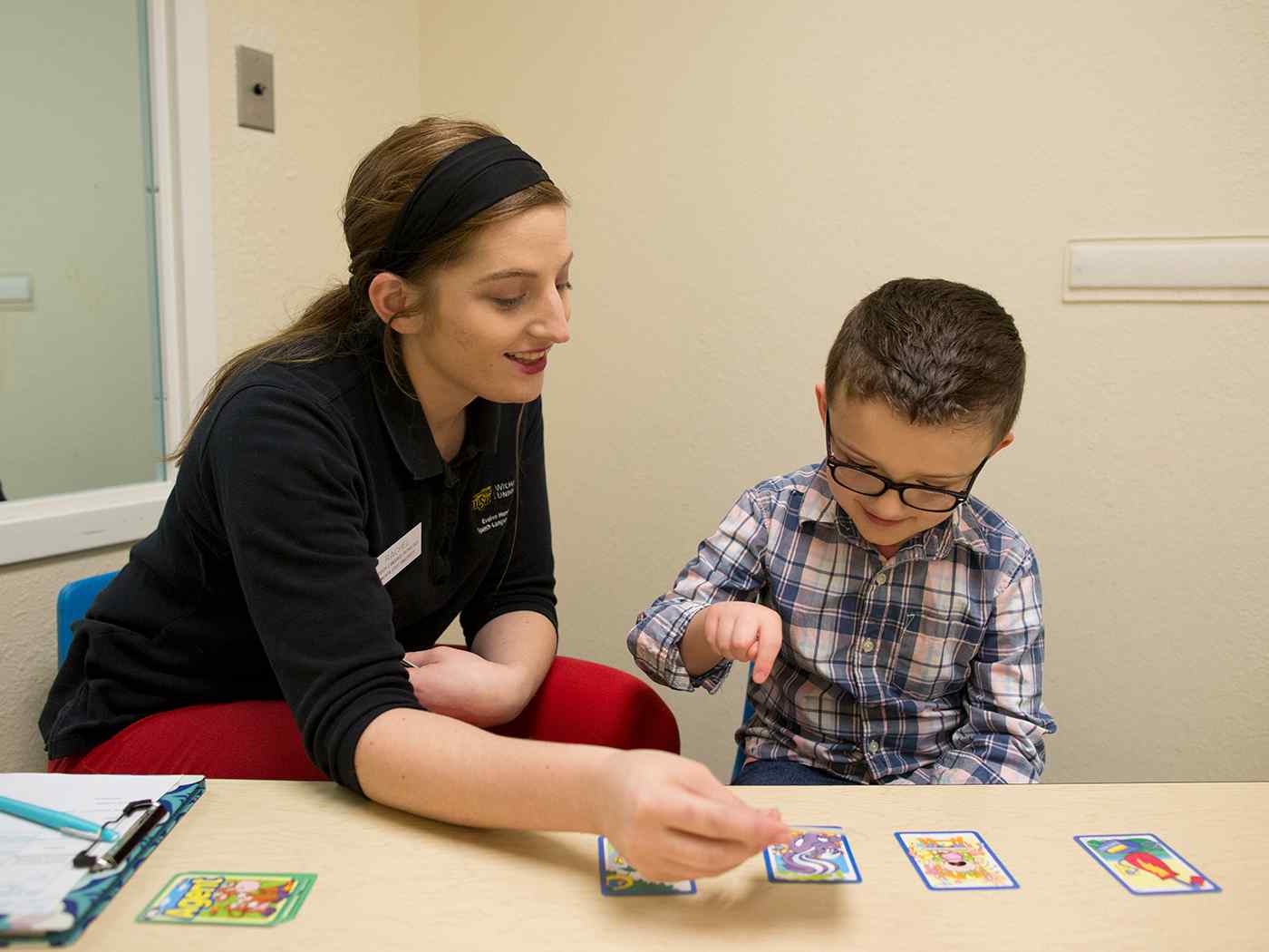 Student teaching a child with flash cards.