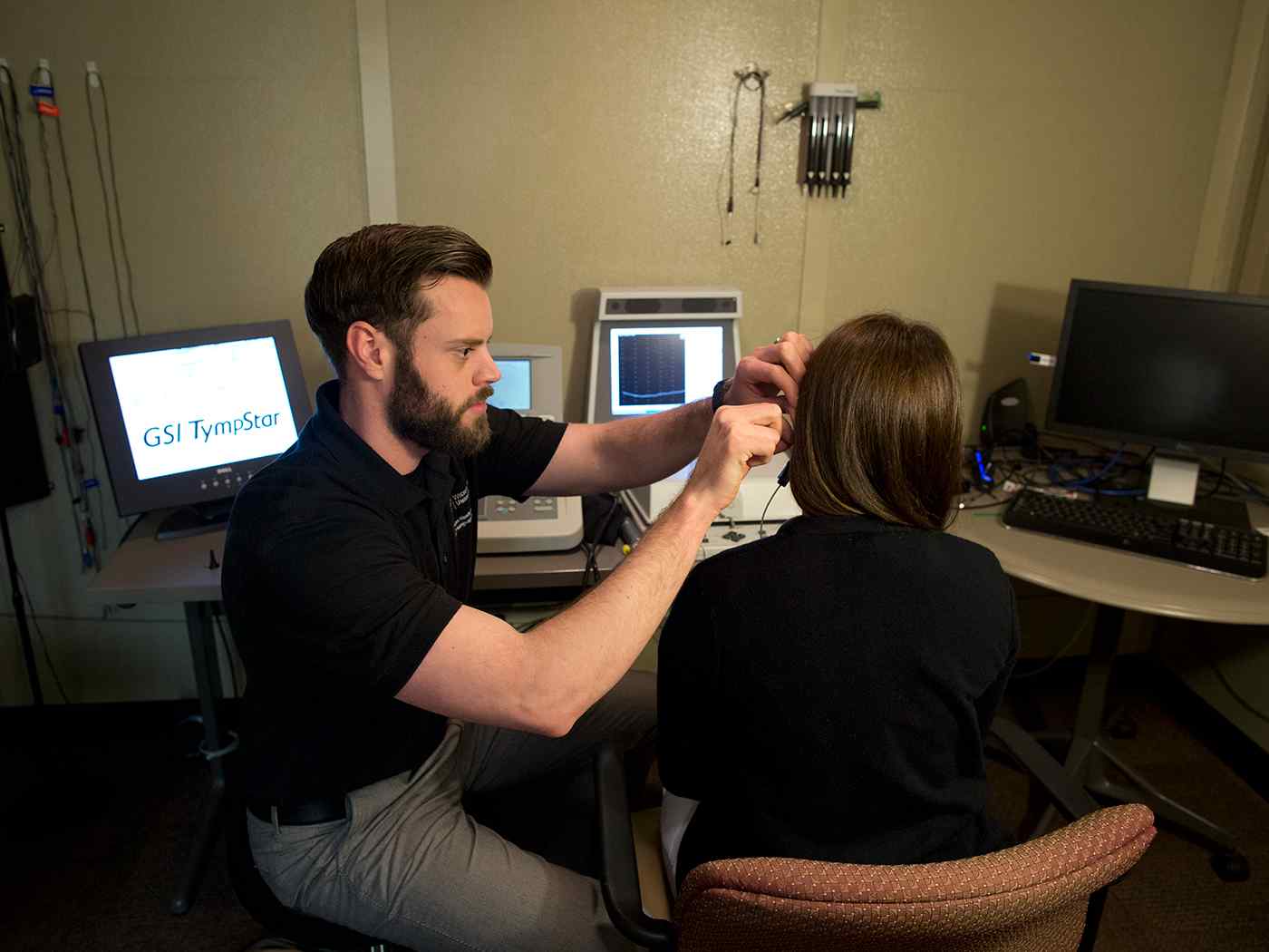 Student examining patient's ear