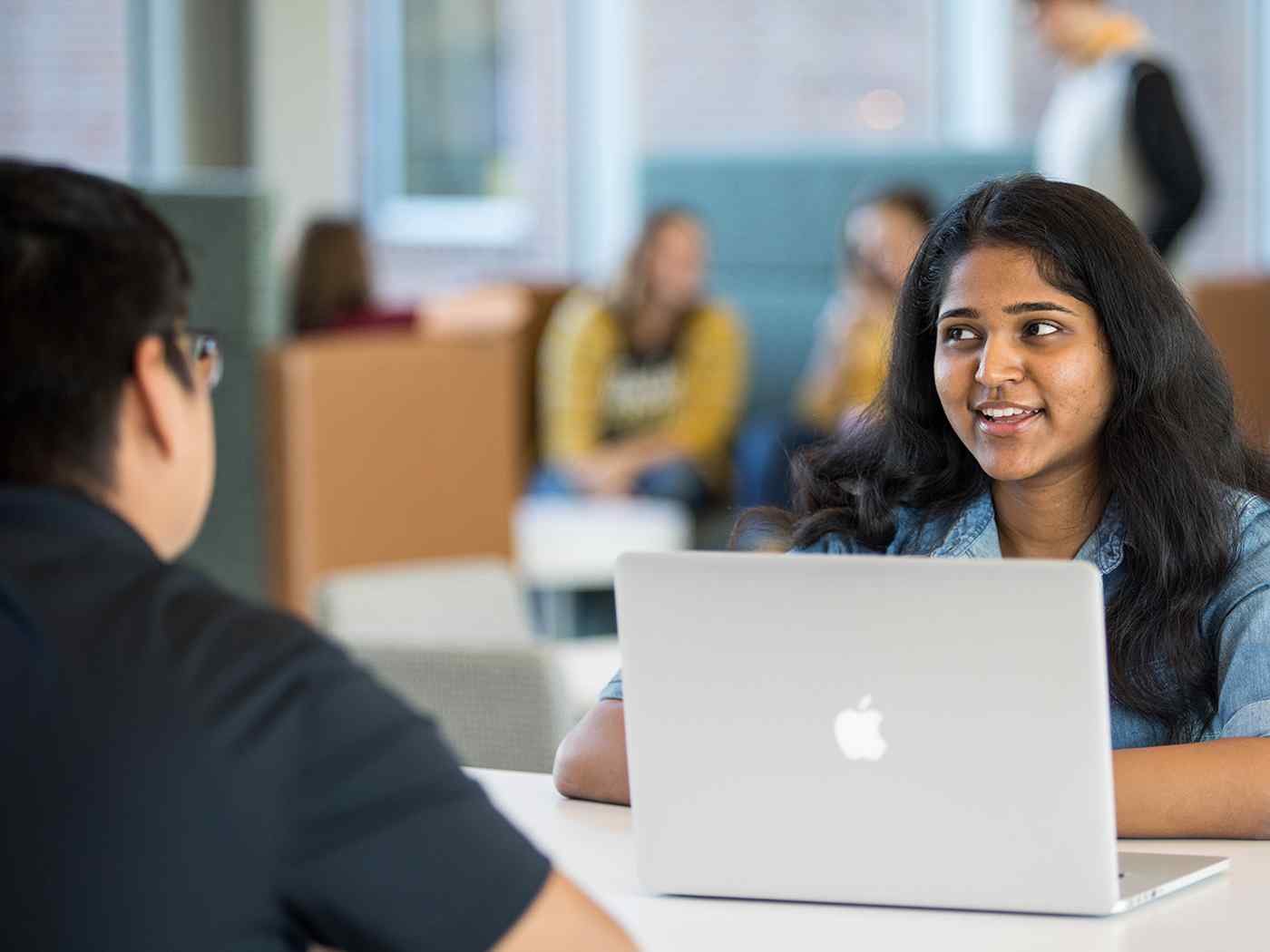 A student with a laptop sits across from another student in John Bardo Center