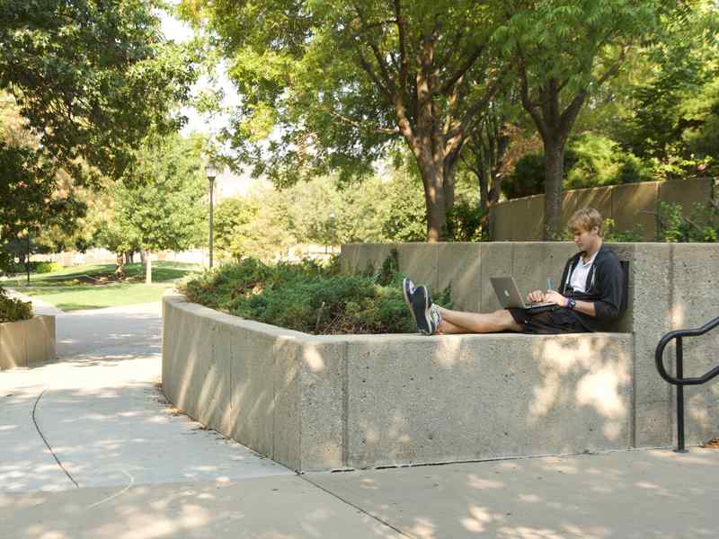 Engineering student studying on his computer on campus.