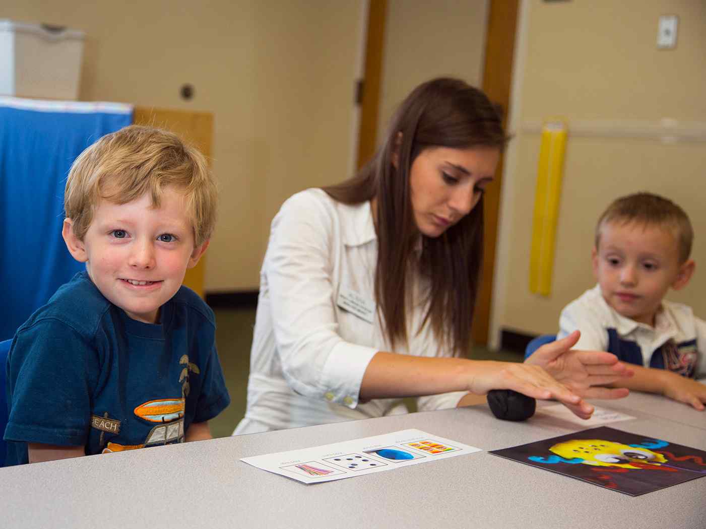 Young child smiling in classroom.