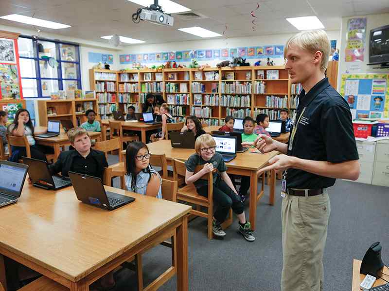 Computer science major Zane Storlie teaching Scratch, an entry-level coding program, to elementary school students.